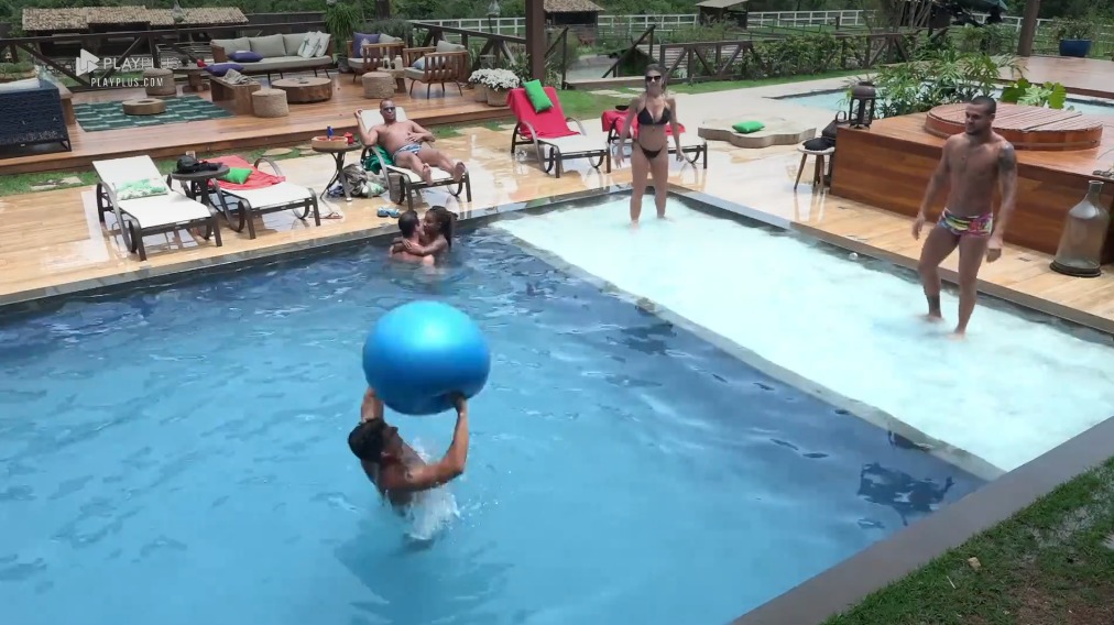 Peões jogam vôlei na piscina