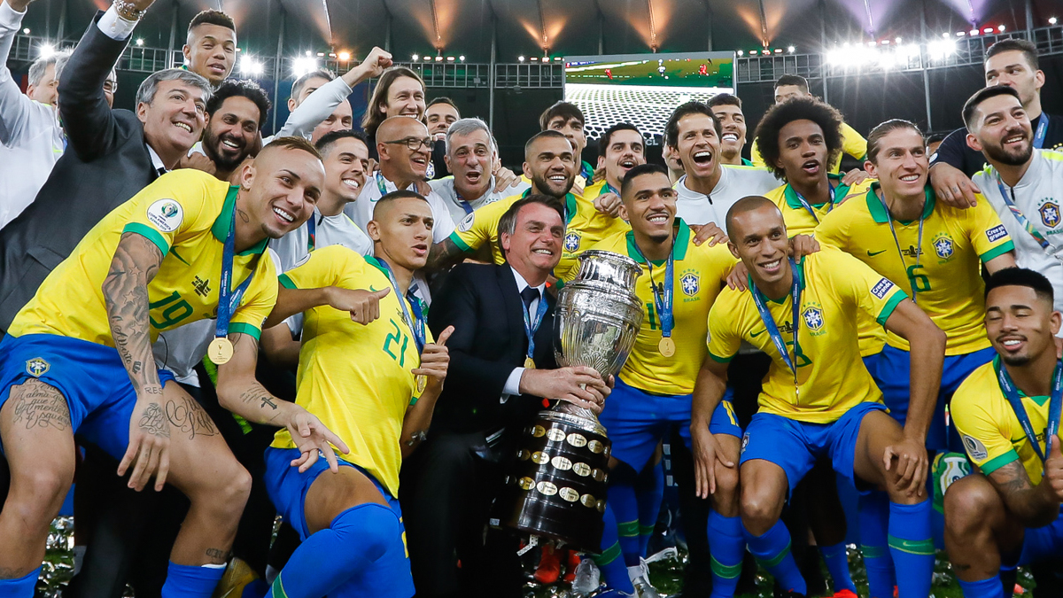 O presidente Jair Bolsonaro posa com a taça da Copa América e a seleção brasileira, no Maracanã, em 2019