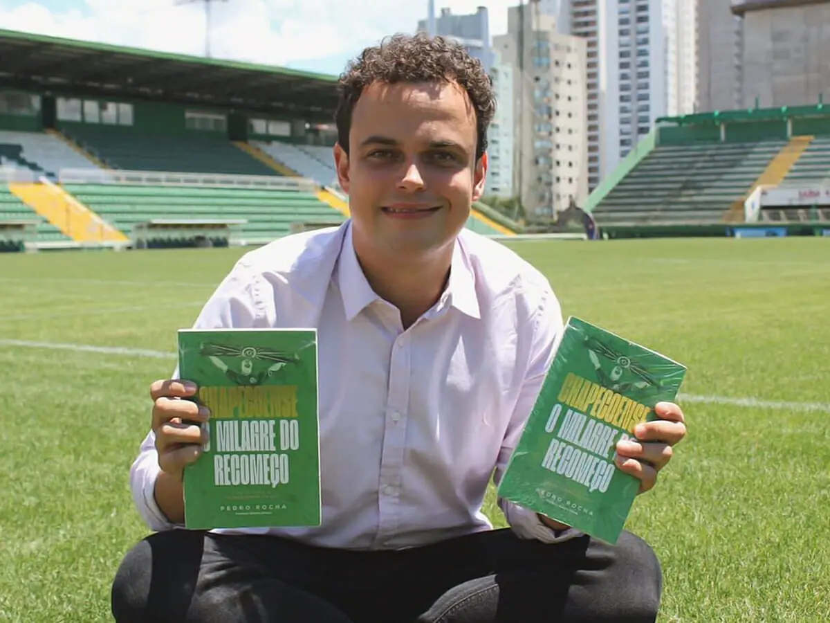 O repórter Pedro Rocha na Arena Condá com dois exemplares de seu livro, Chapecoense, o Milagre do Recomeço